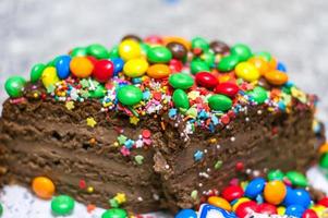 torta al cioccolato con decorazioni colorate foto