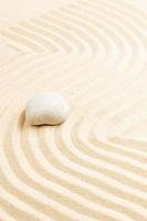 sfondo di pietra di meditazione giardino zen. pietre e linee nella sabbia per l'equilibrio tra relax e armonia della spiritualità o benessere termale. colori naturali foto