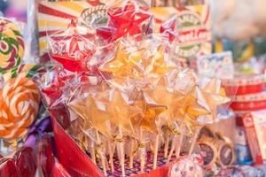 primo piano di lecca-lecca colorate su bastoncini nel mercato di strada foto