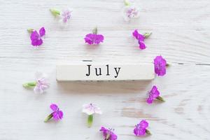 primo giorno di luglio, sfondo colorato con calendario e fiori rosa foto