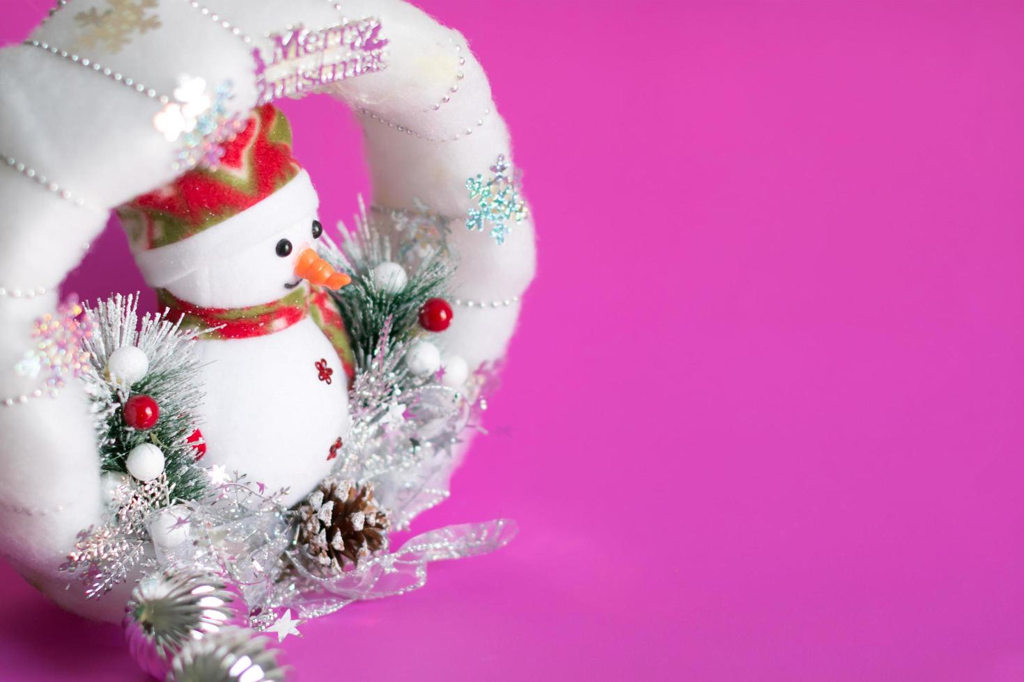 fundo de natal da boneca boneco de neve na guirlanda de natal macia branca com muitas decorações de bugigangas. foto