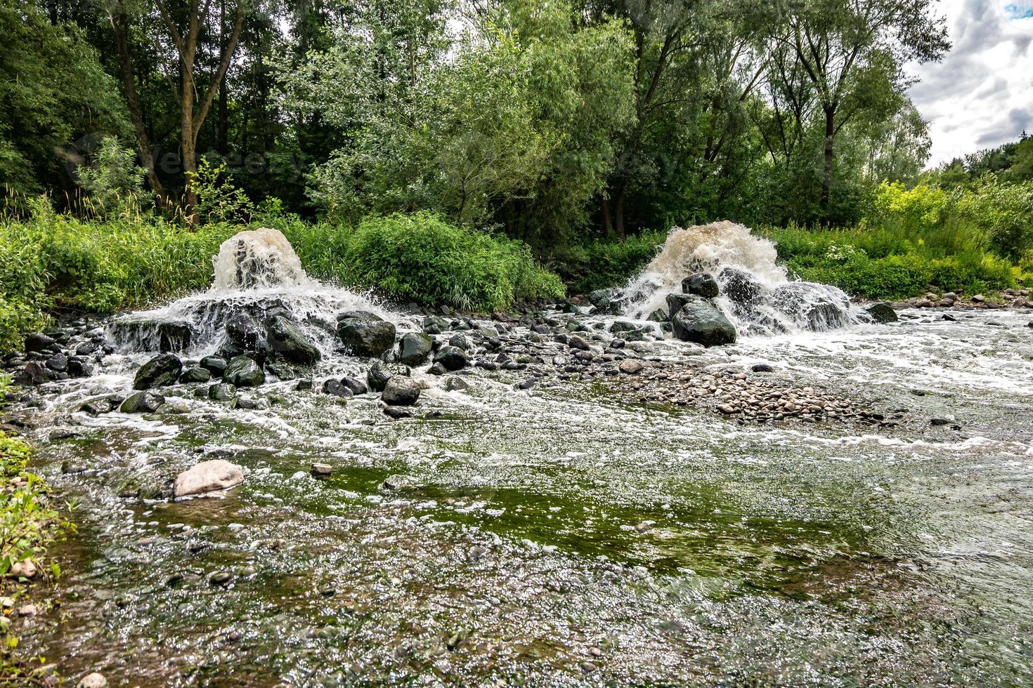 zona de mistura de descarga de esgoto de esgoto urbano. poluição do rio. lixões da cidade foto