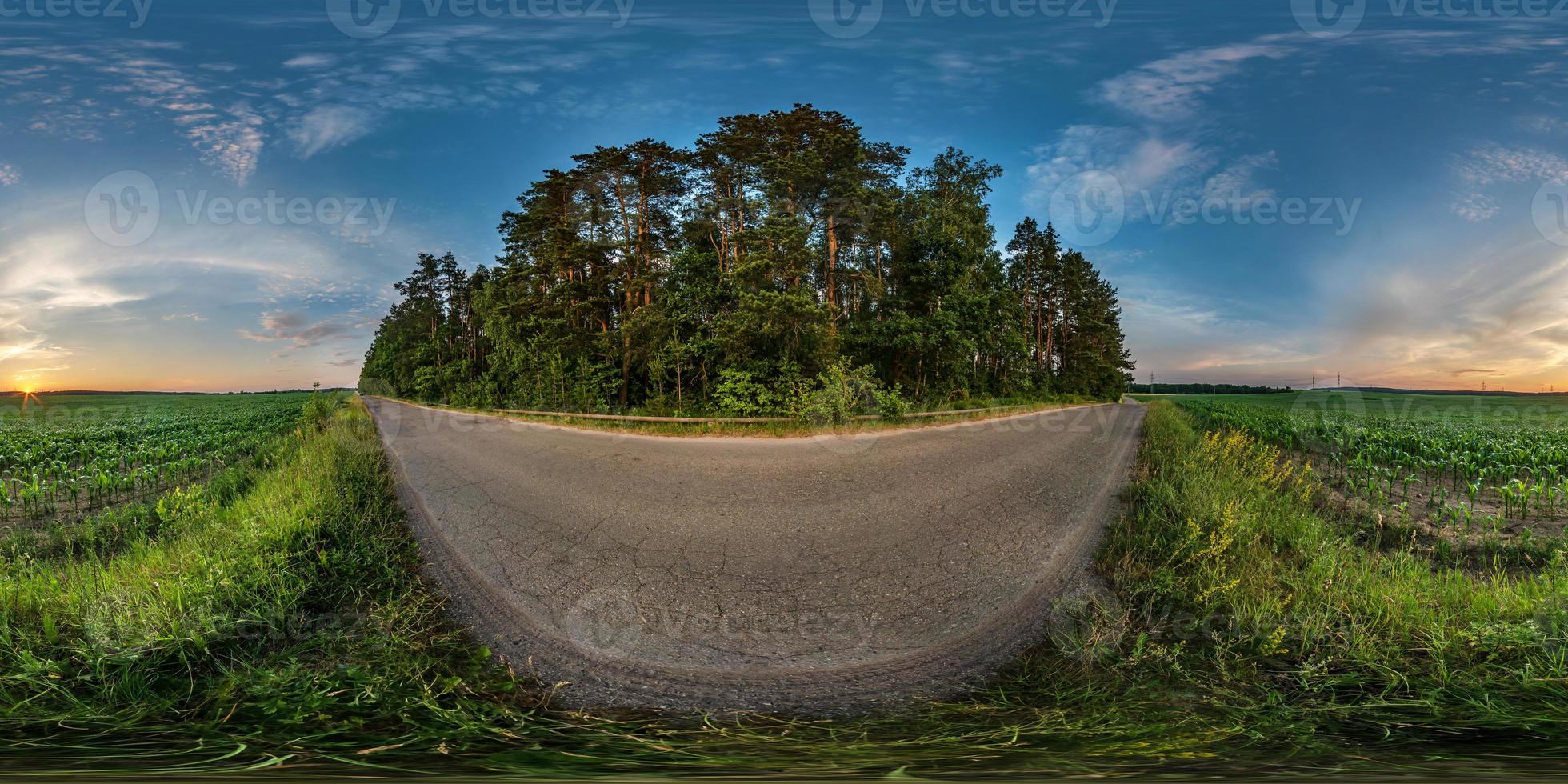 panorama hdri esférico completo sem costura vista de ângulo de 360 graus na estrada de cascalho entre campos no pôr do sol da noite de verão com nuvens impressionantes em projeção equirretangular, conteúdo de realidade virtual vr ar pronto foto