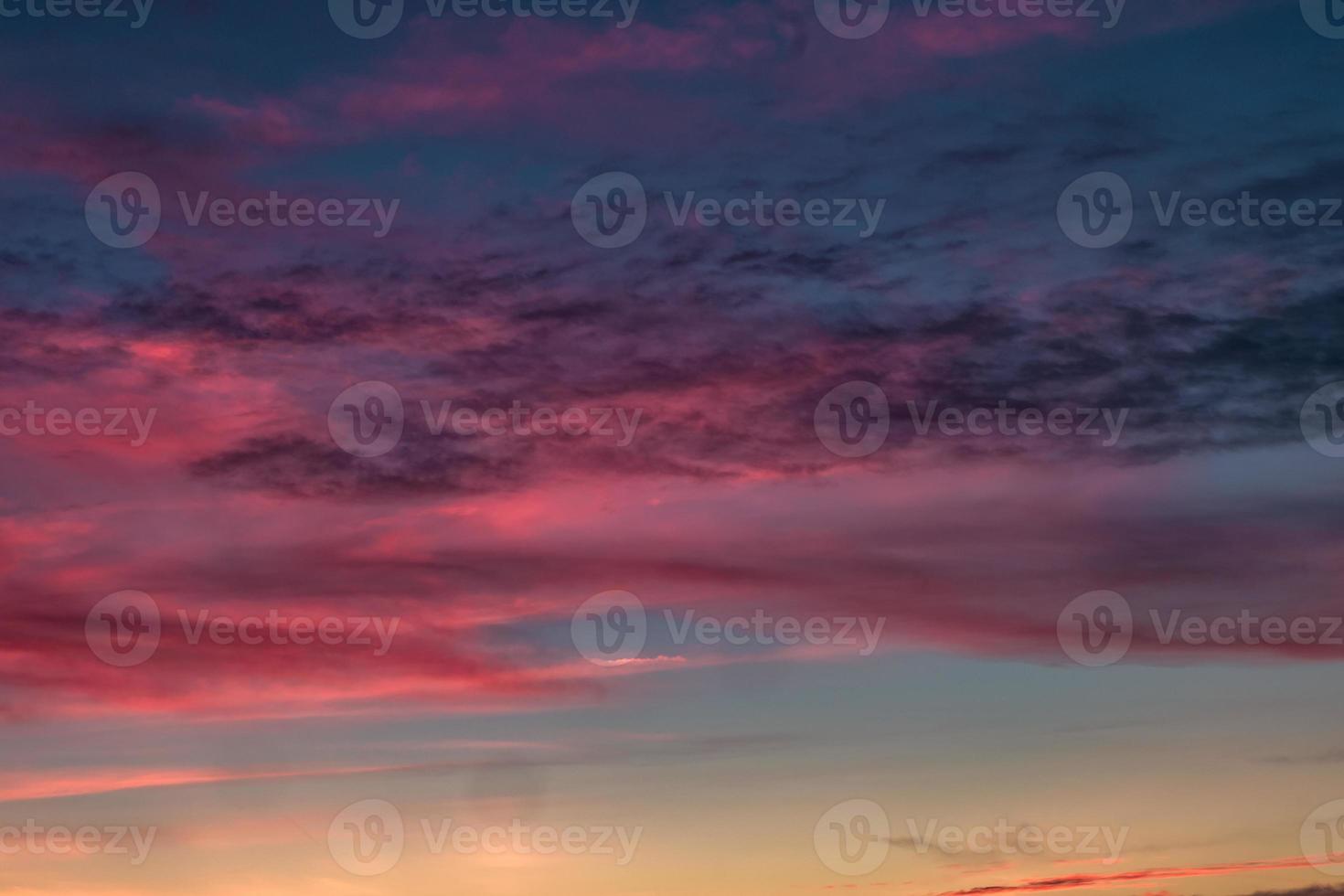 fundo de céu azul violeta vermelho pôr do sol com nuvens de cirrostratus rolando encaracolados fofos à noite. bom tempo ventoso foto