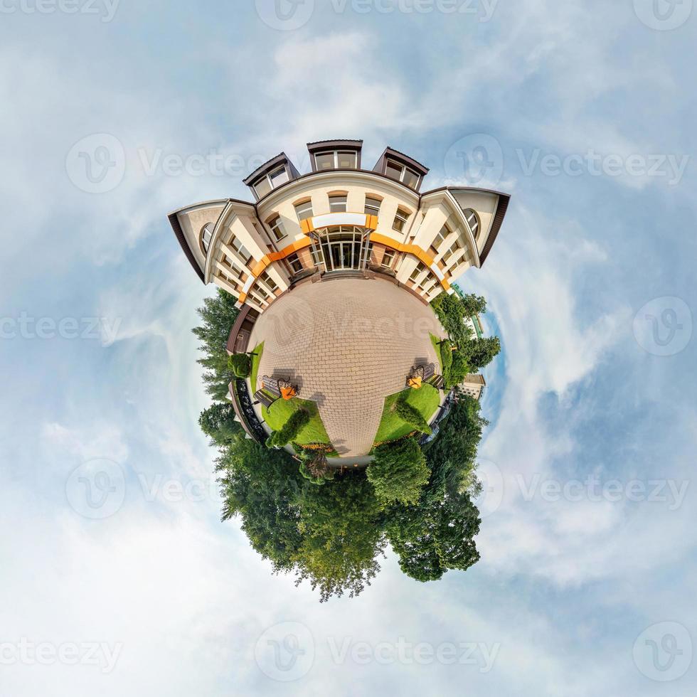 pequeno planeta com árvores perto de belo edifício, nuvens brancas e céu azul suave do parque de diversões. anjo de visão de 360 graus. planeta Terra. foto