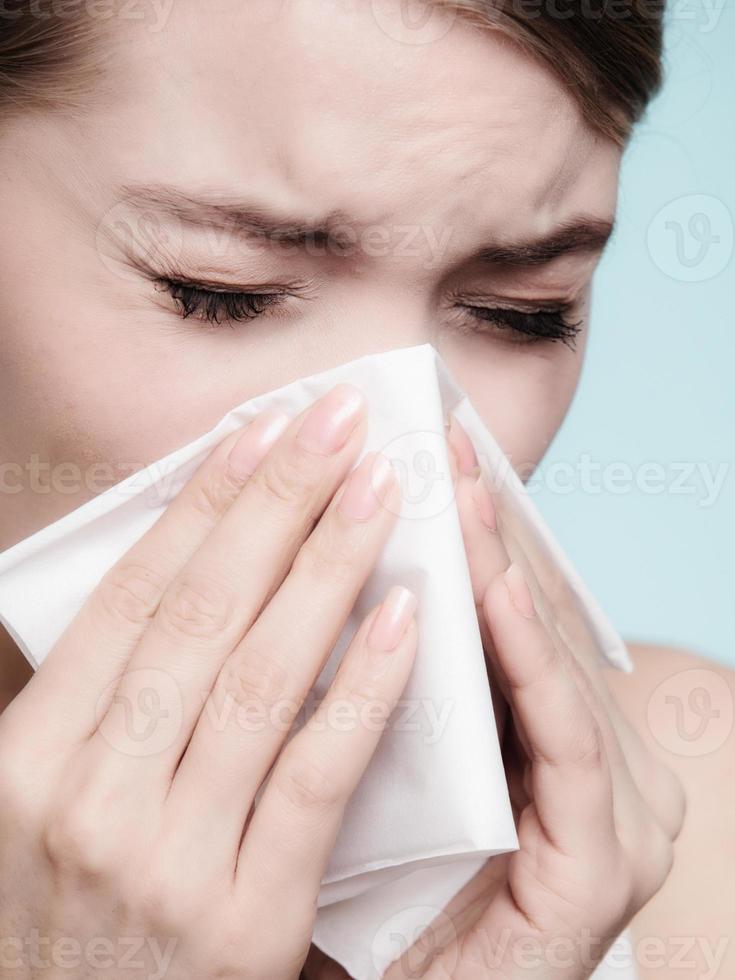 alergia à gripe. garota doente espirros em tecido. saúde foto