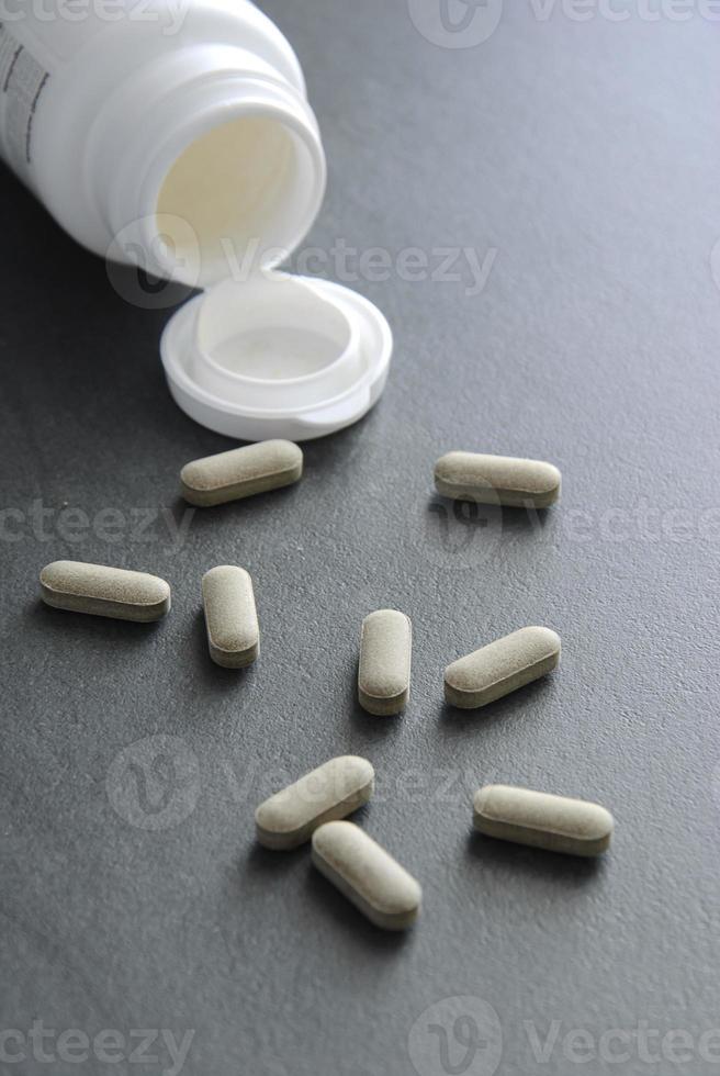 pílulas em fundo escuro foto