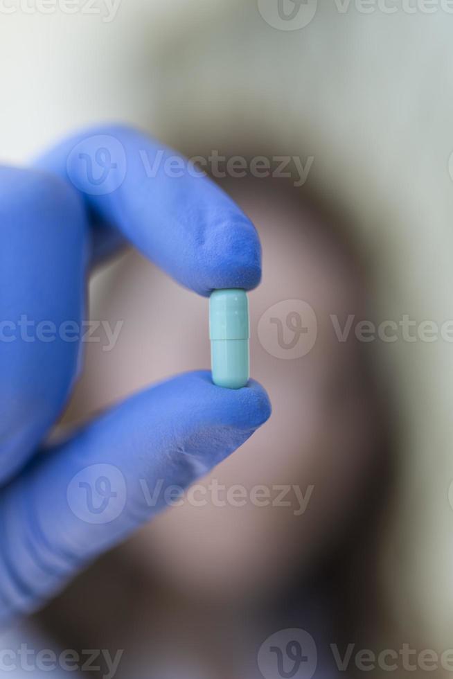 mulher segurando cápsulas de comprimidos azuis foto