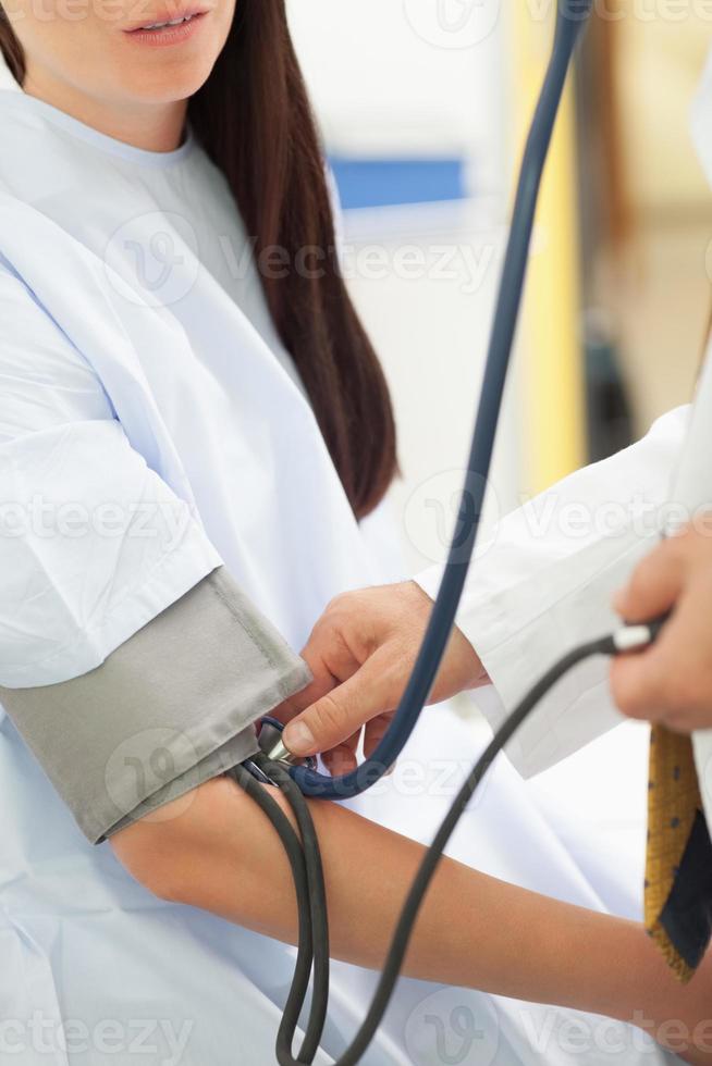 médico medindo a pressão arterial de seu paciente foto