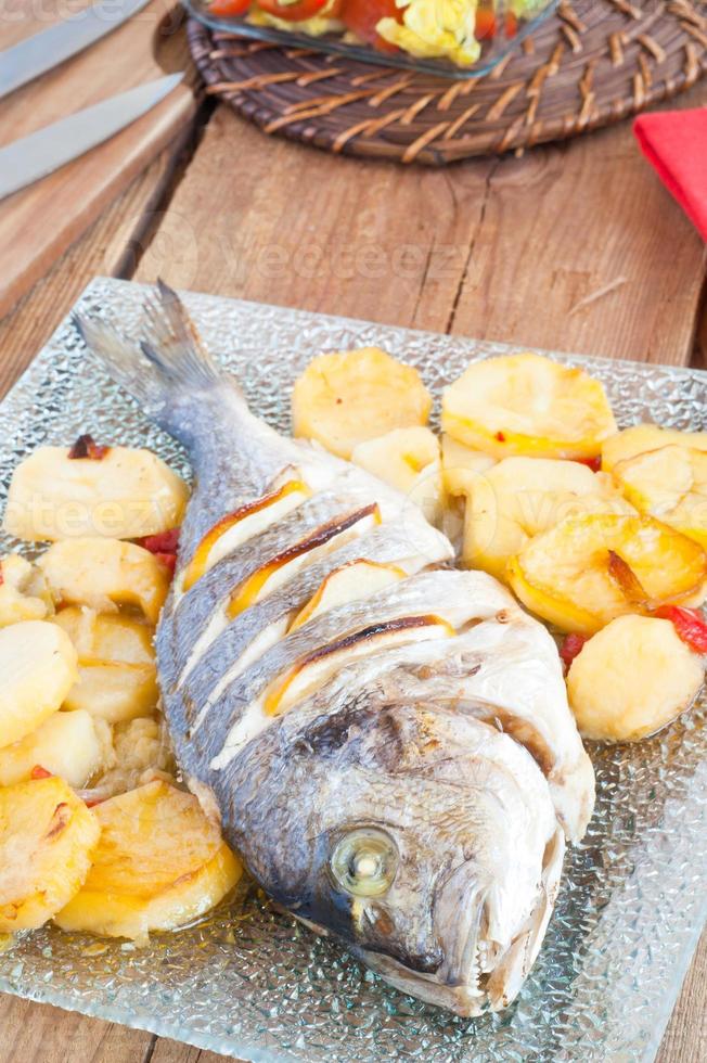 peixe assado com limão e batatas foto