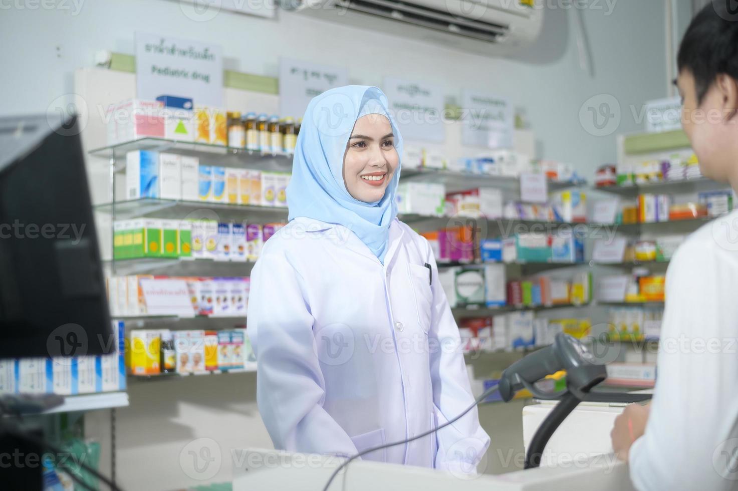 farmacêutico muçulmano feminino aconselhando o cliente sobre o uso de drogas em uma farmácia moderna. foto