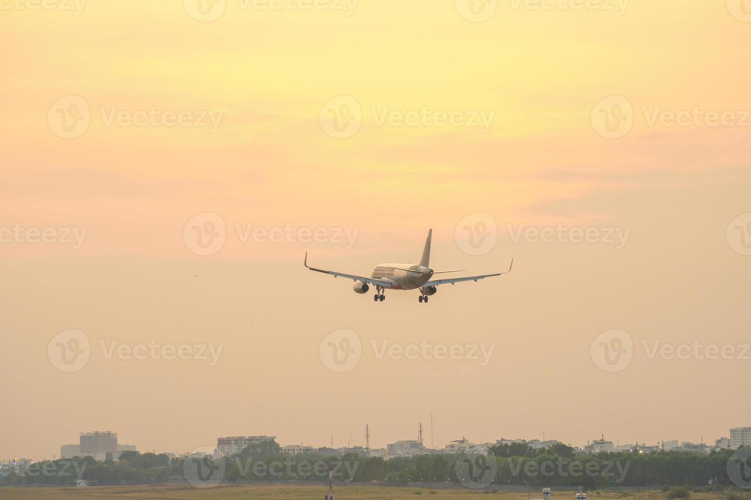 cidade de ho chi minh, vietnã - 20 de fevereiro de 2022 avião sobrevoa áreas urbanas preparando o pouso no aeroporto internacional tan son nhat e decola no aeroporto tsn foto