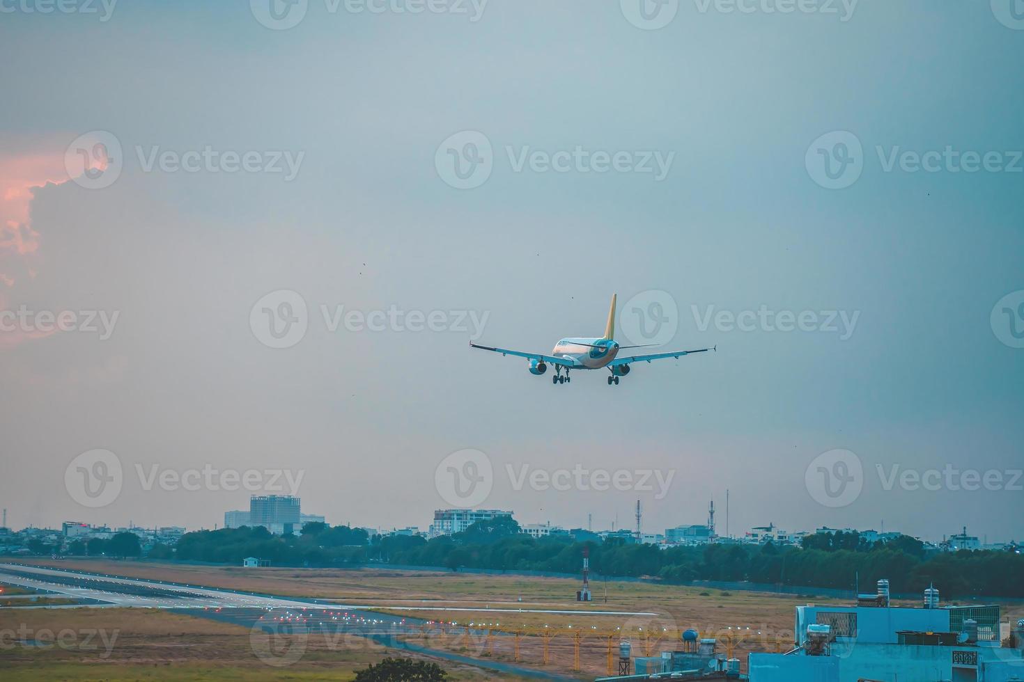 cidade de ho chi minh, vietnã - 12 de fevereiro de 2022 avião sobrevoa áreas urbanas preparando o pouso no aeroporto internacional tan son nhat e decola no aeroporto tsn foto