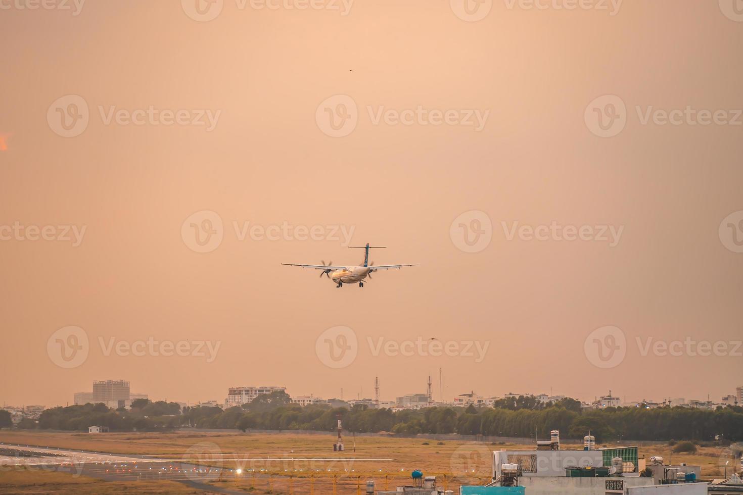 cidade de ho chi minh, vietnã - 12 de fevereiro de 2022 avião sobrevoa áreas urbanas preparando o pouso no aeroporto internacional tan son nhat e decola no aeroporto tsn foto