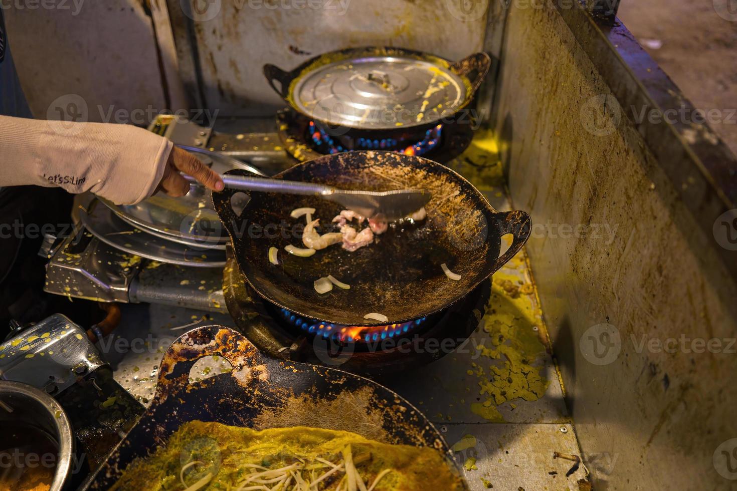 crepes vietnamitas banh xeo recheados com carne de porco ou frango também, camarão, cebola e broto de feijão e molho picante colocado perto do prato na mesa foto