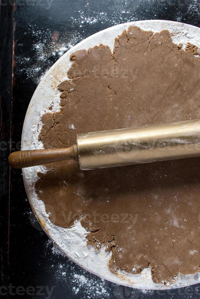 massa de pão de gengibre em mármore redondo com vista superior de rolo de ouro foto