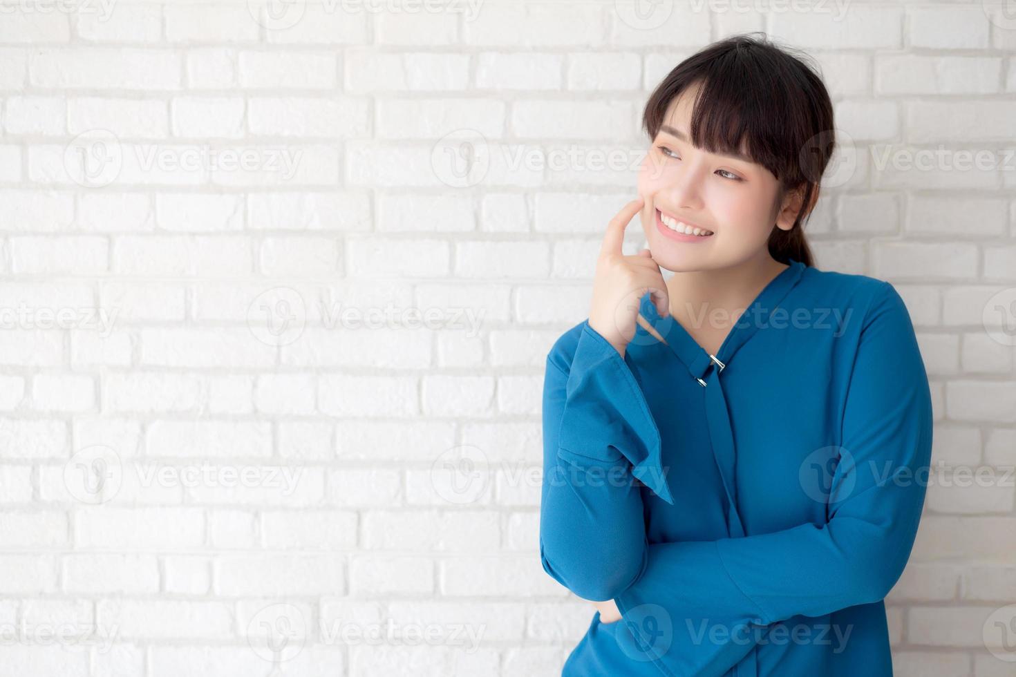 belo retrato jovem mulher asiática sorrindo e confiante pensando com cimento e fundo de concreto, menina em pé expressão séria ou dúvidas com ideia e inspiração, conceito de estilo de vida. foto