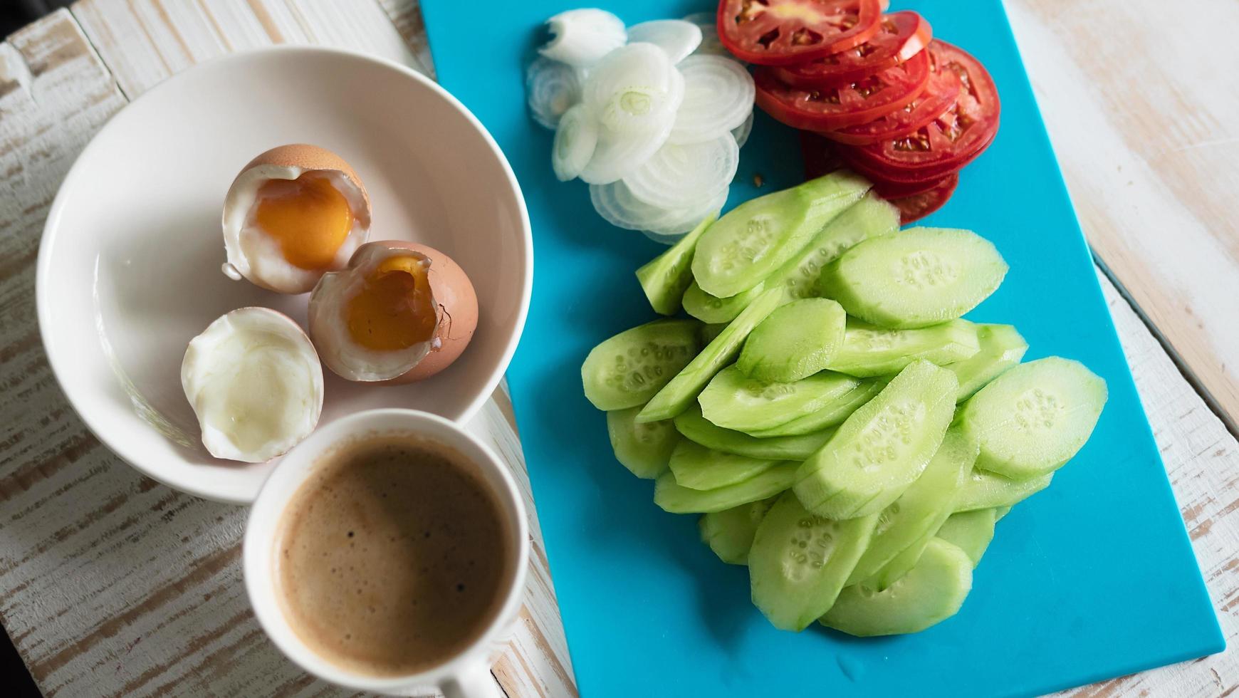 ovos cozidos com salada de pepino fresco e café da manhã xícara de café - conceito de comida de café da manhã vista superior foto