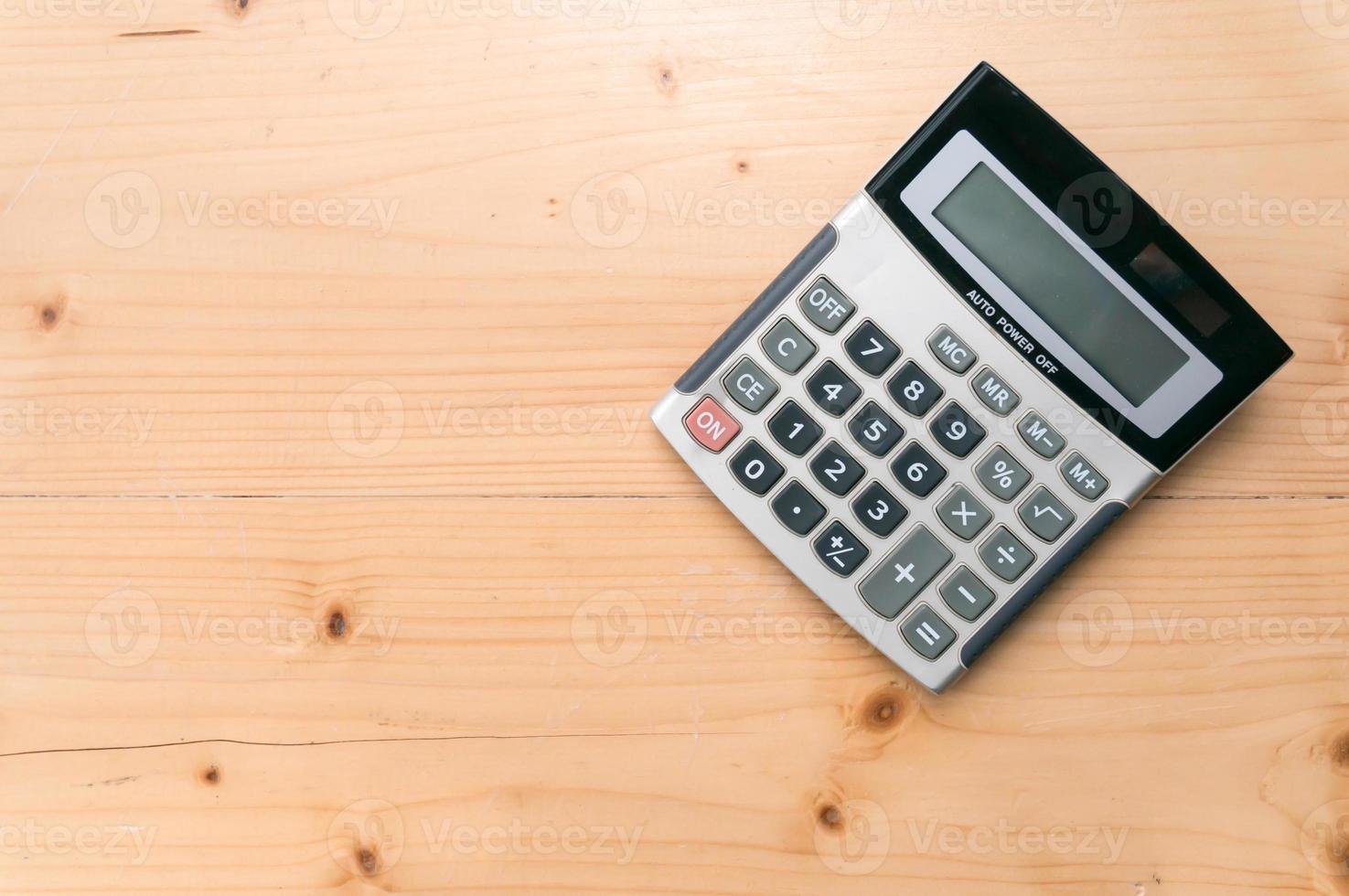 calculadora no fundo da mesa de madeira. espaço livre para texto. foto