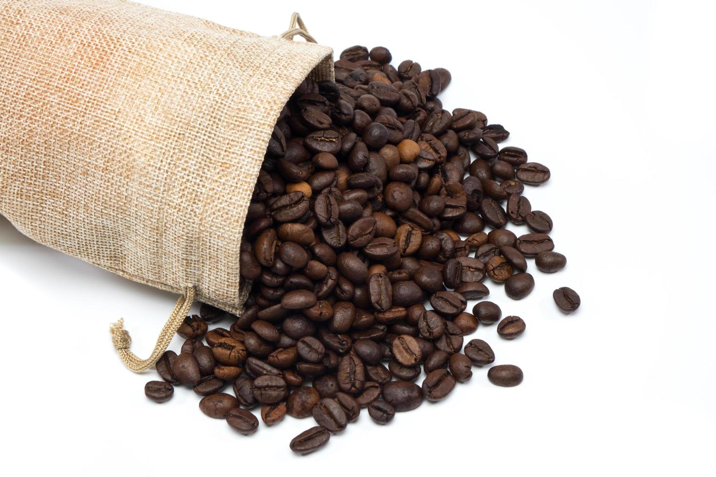 grãos de café com saco de estopa no fundo branco foto