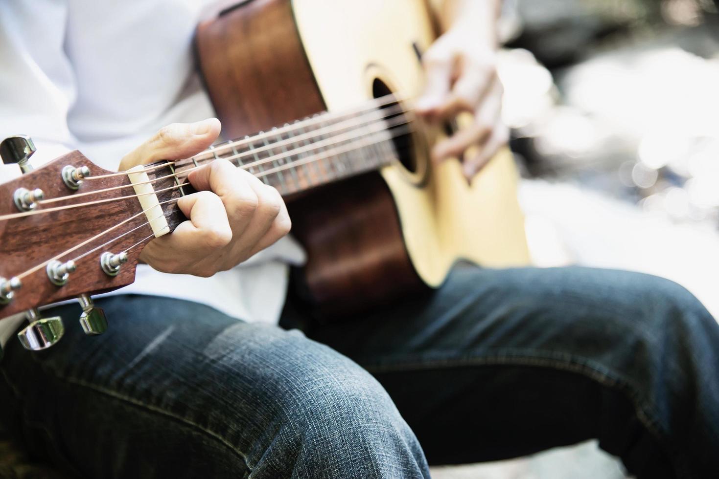 homem toca ukulele novo na cachoeira - estilo de vida de pessoas e instrumentos musicais no conceito de natureza foto