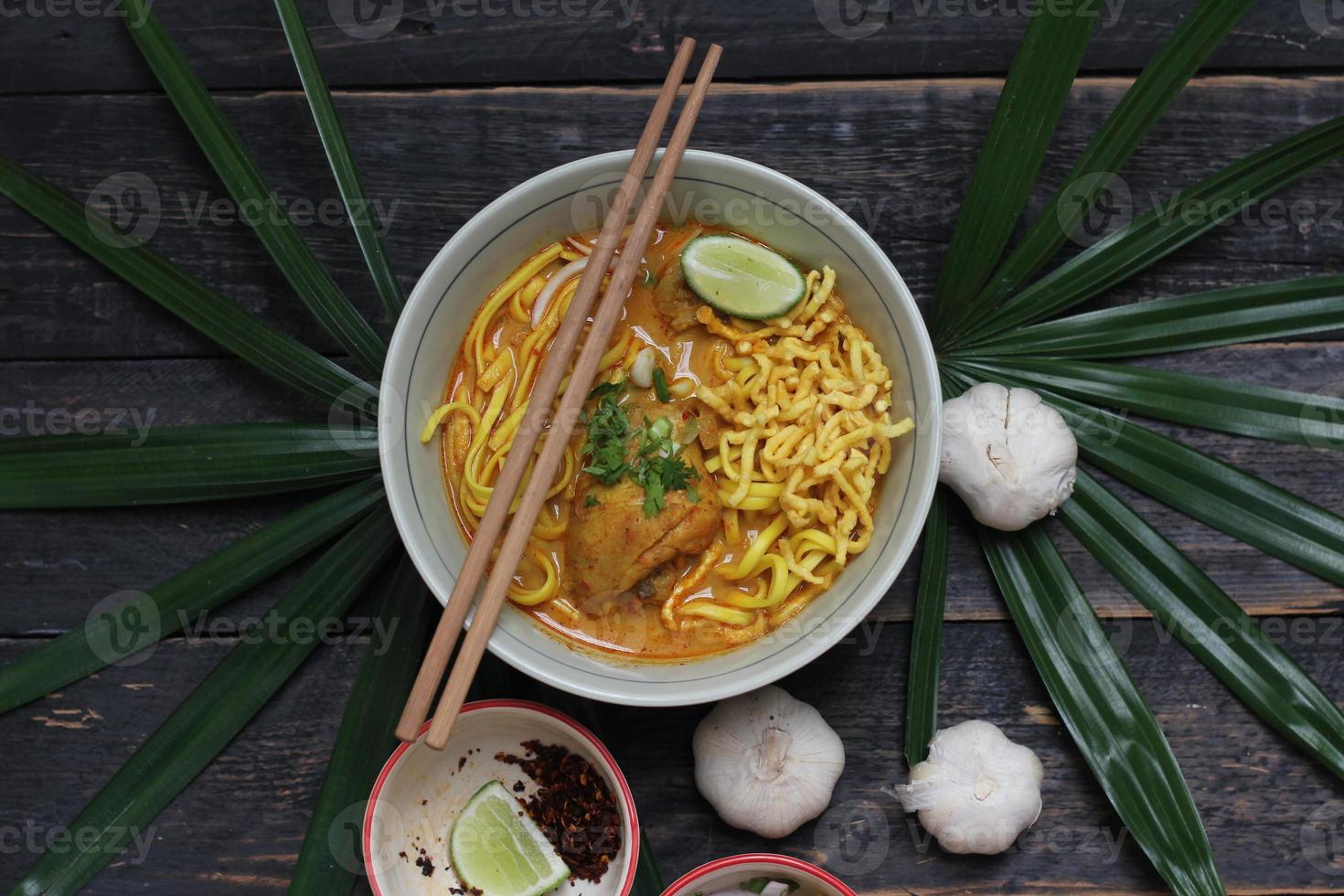 receita de khao soi, khao soi, khao soi kai, macarrão tailandês khao soi, curry de frango com tempero servido na mesa de madeira foto