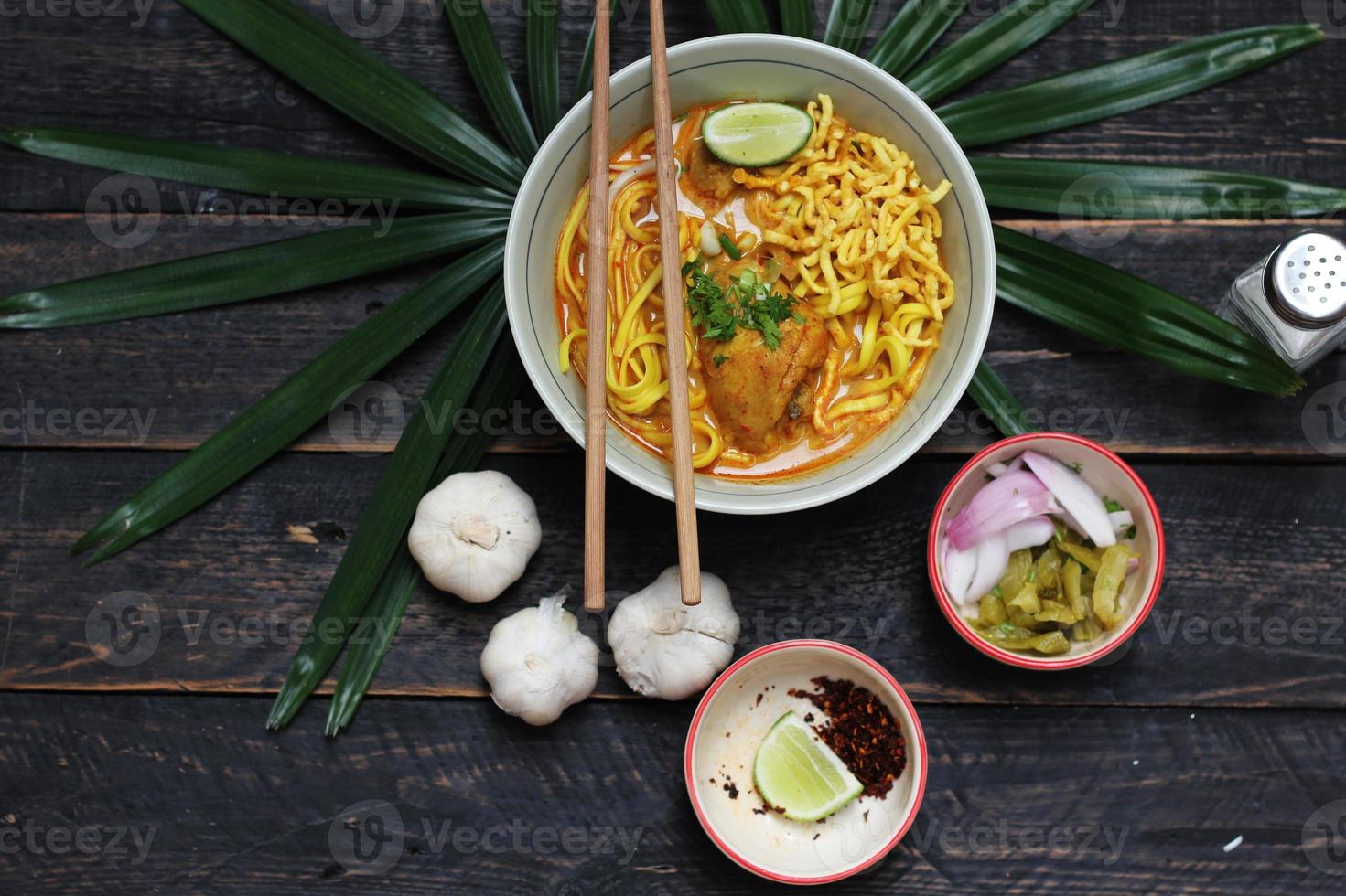 receita de khao soi, khao soi, khao soi kai, macarrão tailandês khao soi, curry de frango com tempero servido na mesa de madeira foto