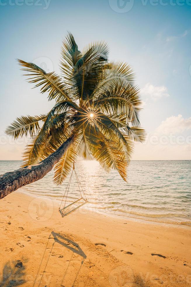 paisagem do sol da praia tropical com balanço de praia ou rede e céu pôr do sol areia branca e mar calmo para banner de praia. férias de cena de praia perfeita e conceito de férias de verão. aumentar o processo de cor foto