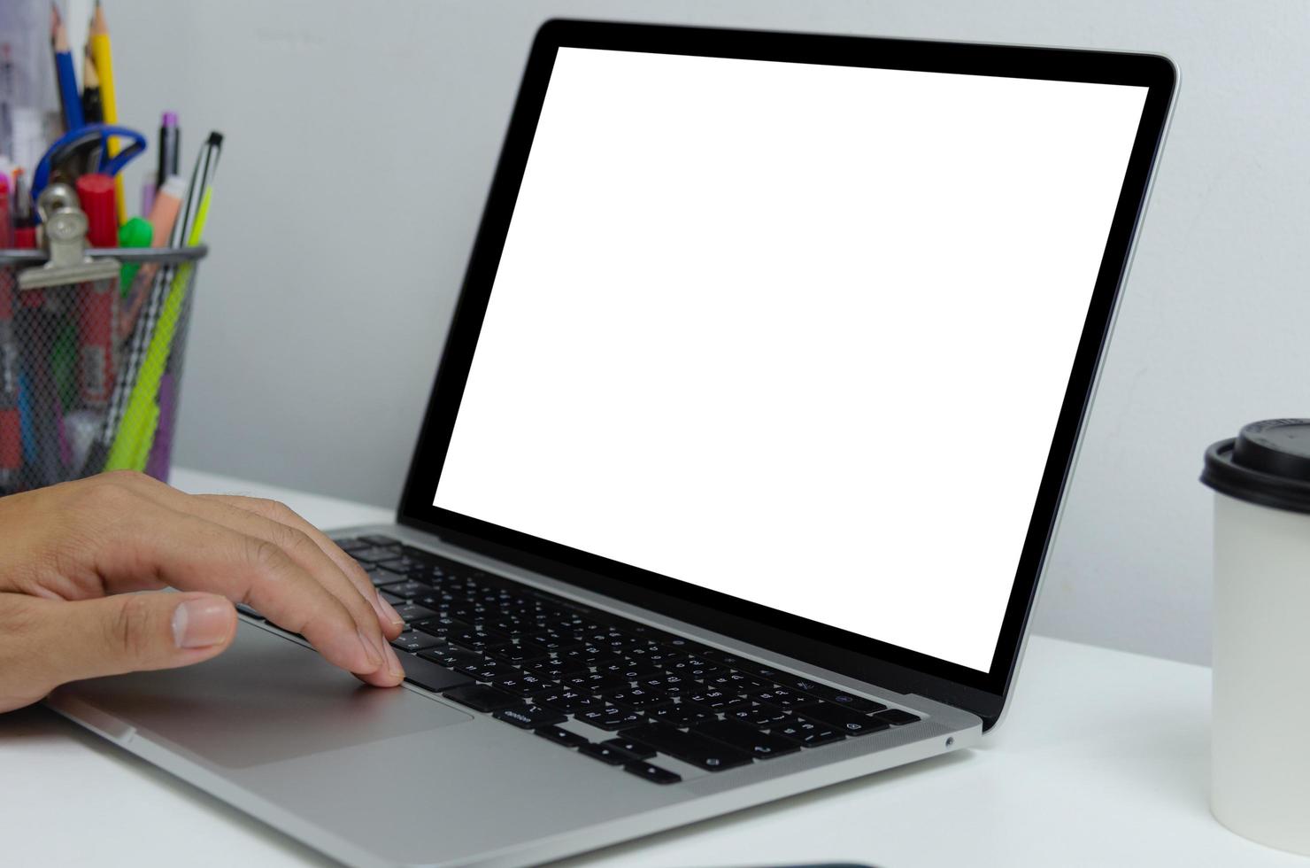 homem de mão usando teclado computador laptop simulado em branco tela branca monitor tecnologia on-line internet conceito de negócio de publicidade digital. foto