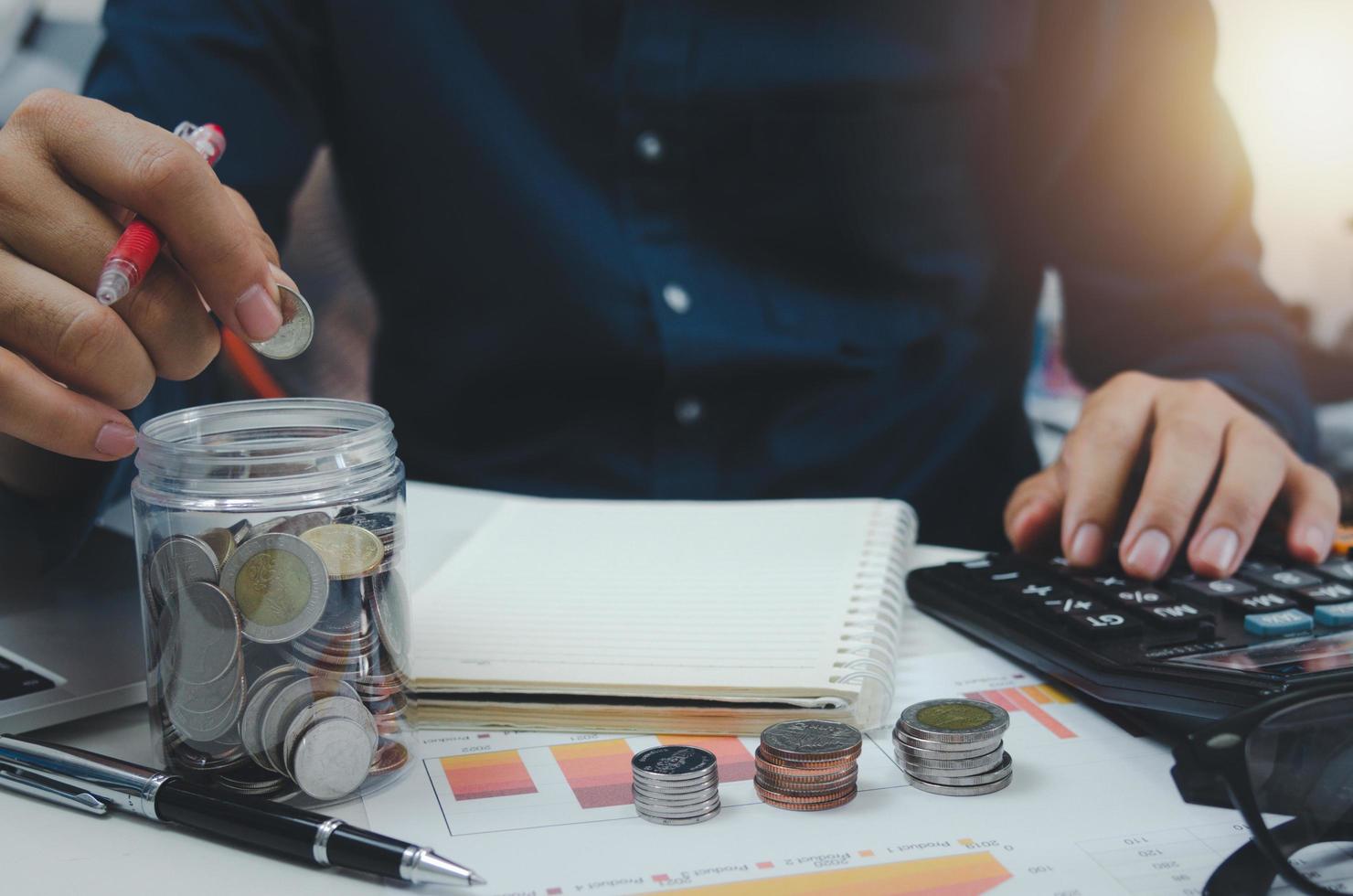 empresário é mostrado segurando uma jarra com moedas para poupança e investimentos. conceito de pagamentos de impostos e contabilidade empresarial. foto