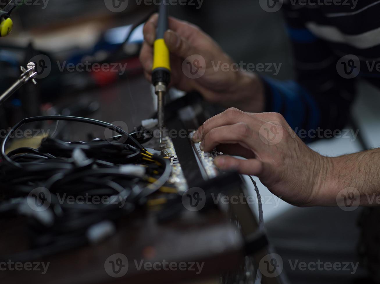 homem trabalhador industrial soldando cabos de equipamentos de fabricação em uma fábrica. foco seletivo foto