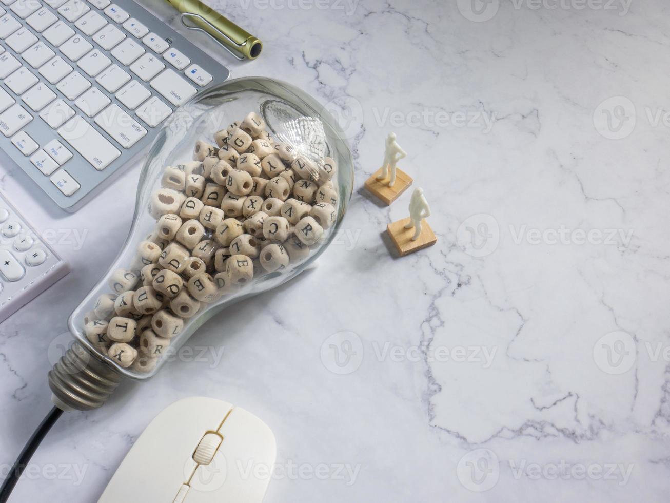 lâmpada e cubo de madeira alfabeto em mármore branco para ideia ou conceito de pensamento foto