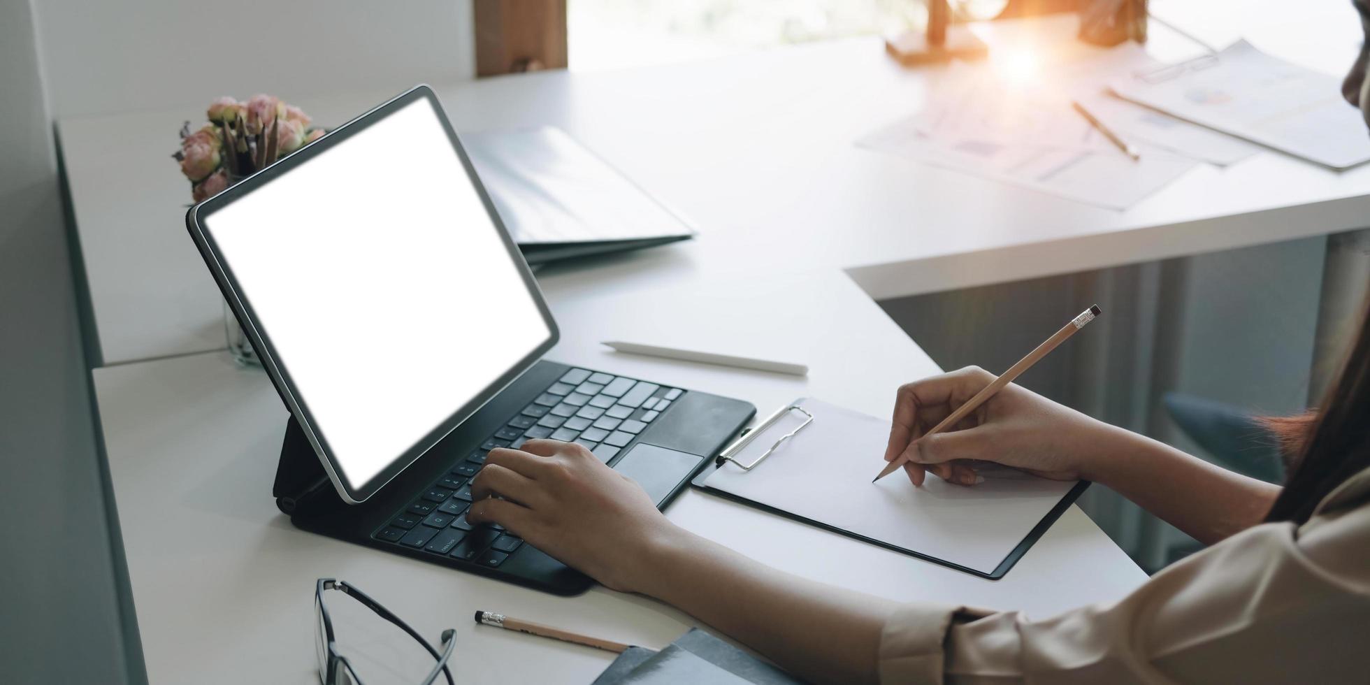 vista lateral de uma empresária trabalhando em uma tela branca em branco do laptop no escritório. brincar. foto