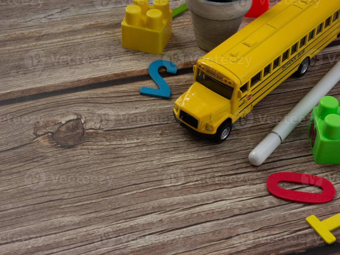 ônibus escolar na mesa de madeira para educação ou volta ao conceito de escola foto