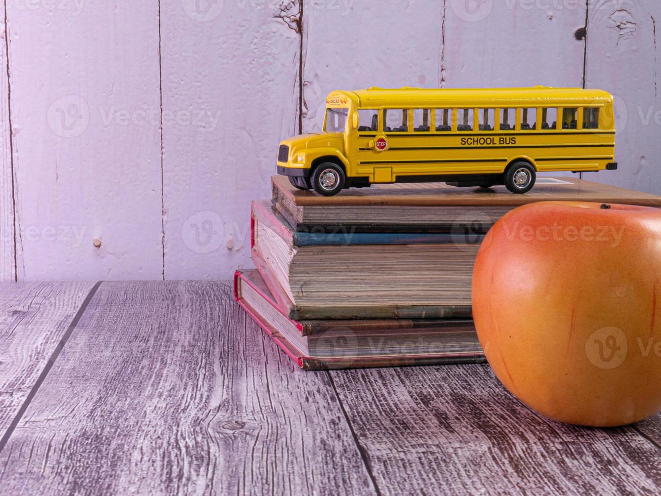 ônibus escolar na mesa de madeira para o conceito de educação foto