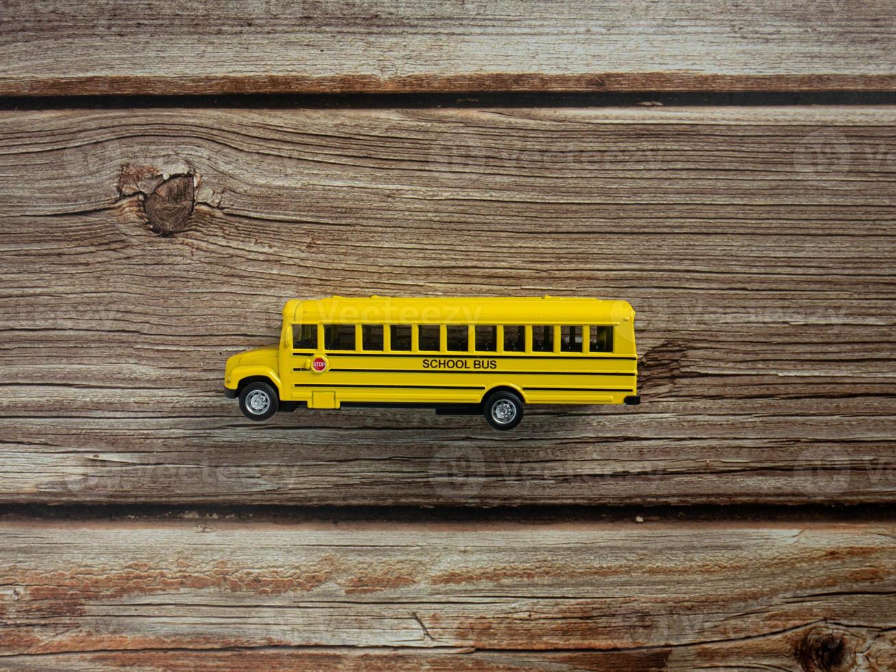o ônibus escolar na mesa de madeira para educação ou volta ao conceito de escola foto