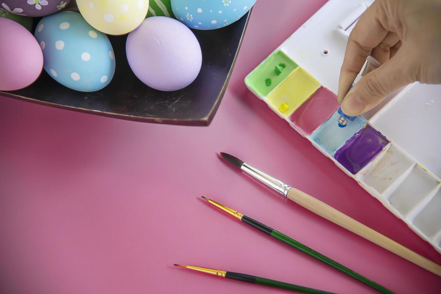 pessoas pintando ovos de páscoa coloridos - conceito de celebração do feriado de páscoa foto