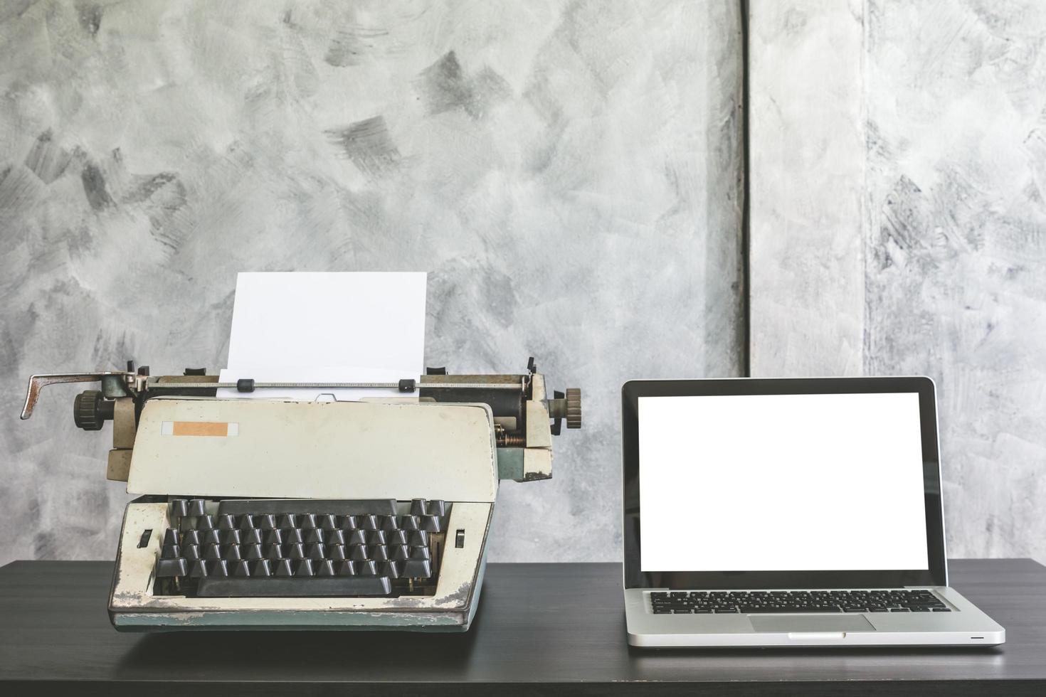 velha máquina de escrever e laptop na mesa. foto
