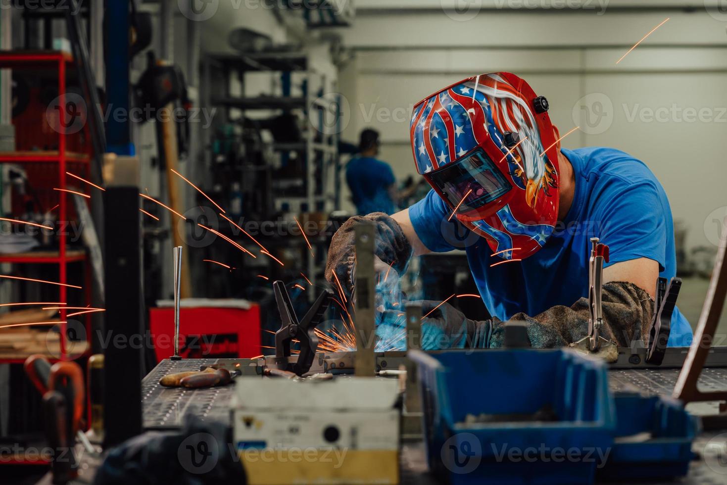 soldador profissional da indústria pesada trabalhando dentro da fábrica, usa capacete e começa a soldar. foco seletivo foto