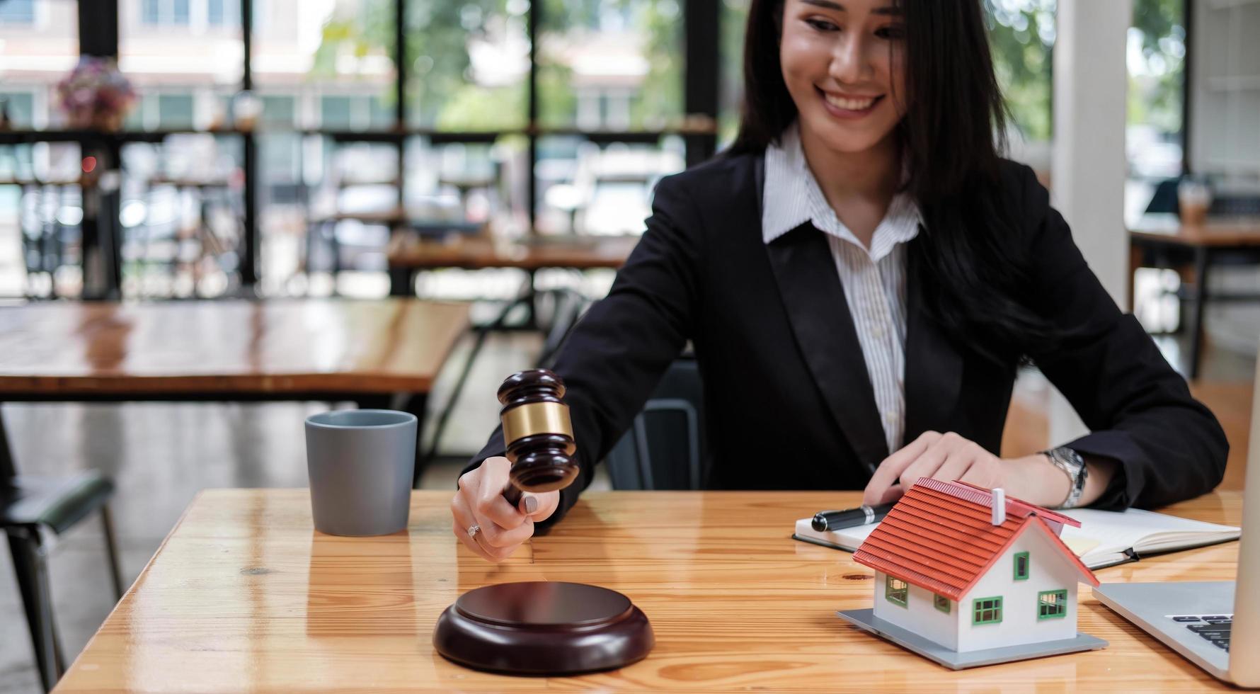 mulher de negócios ou advogados trabalhando na mesa de madeira no escritório. direito, serviços jurídicos, consultoria, leilão de juiz e conceito imobiliário. foto