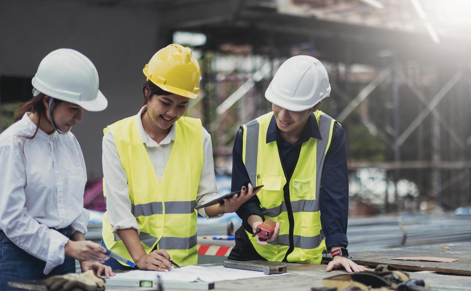 três especialistas inspecionam locais de construção de edifícios comerciais, edifícios industriais projetos imobiliários com engenheiros civis, investidores usam laptops em casa de fundo, enquadramento de cofragem de concreto. foto