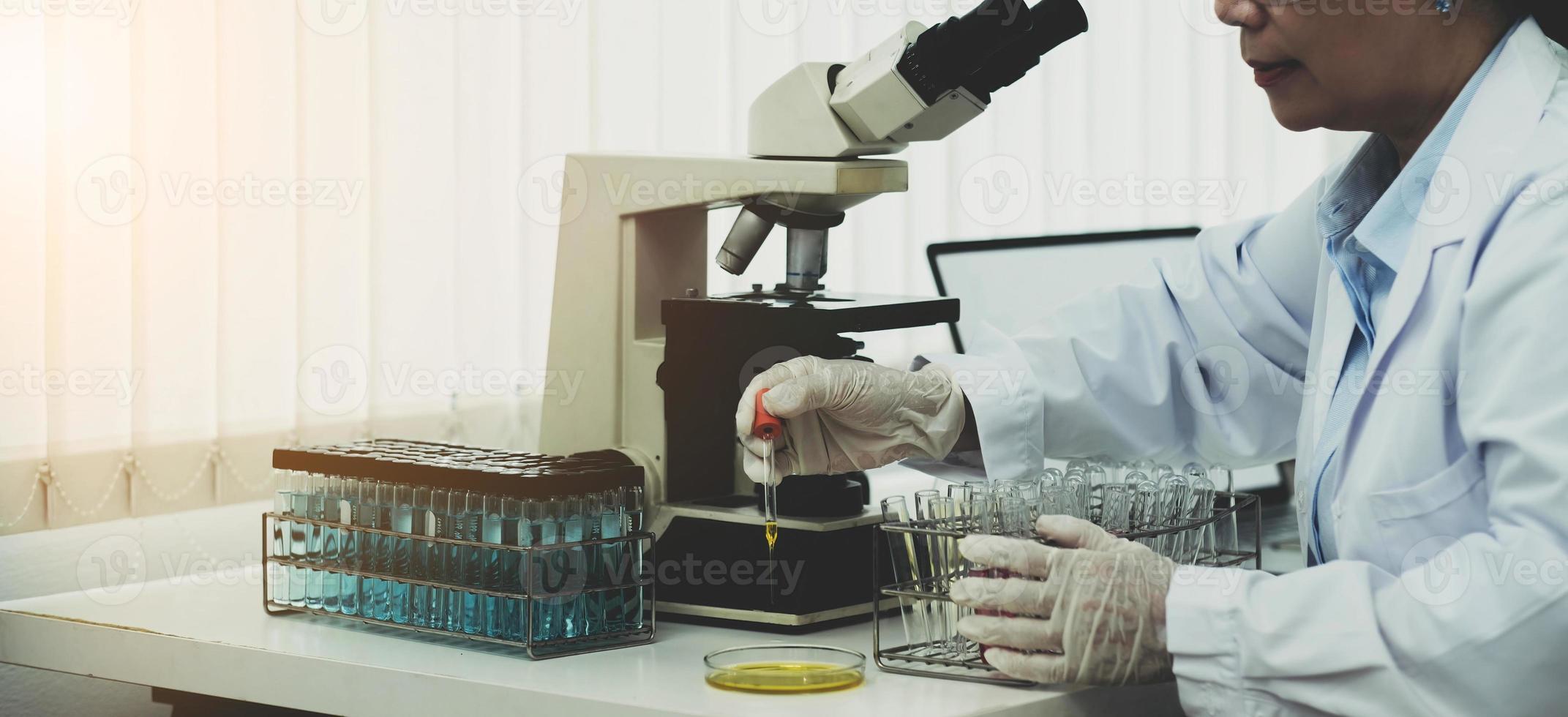 um médico que trabalha em uma mulher sênior de ciência de laboratório de pesquisa fazendo experimentos com drogas. conceito de química, medicina, bioquímica, biotecnologia. e cuidados de saúde foto