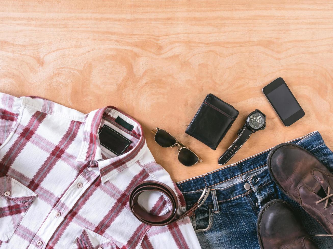 vista superior de roupas casuais masculinas com acessórios no fundo da mesa de madeira foto