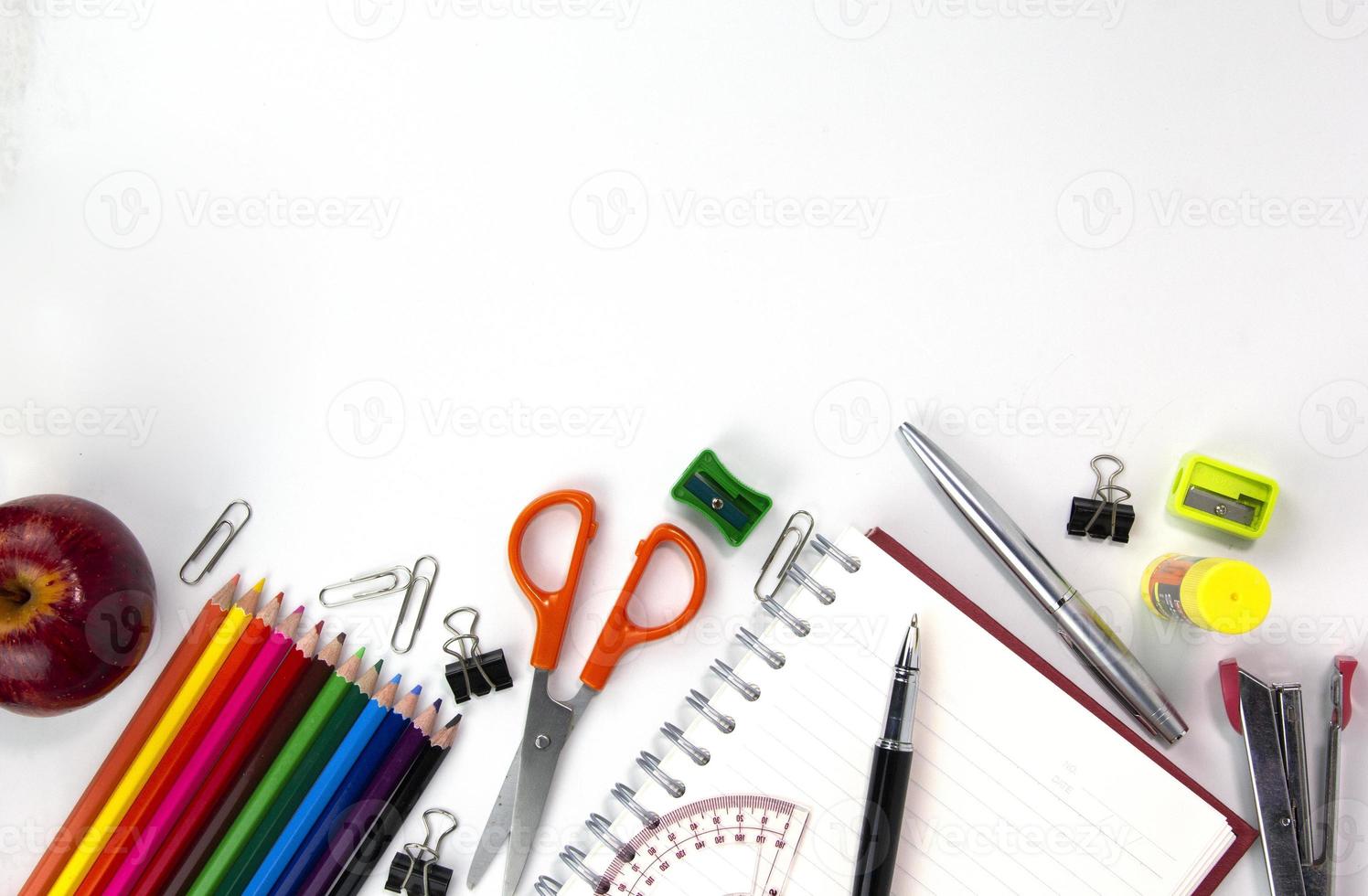 elementos de educação criativa no backgroup branco, usado no conceito de volta à escola. vista superior de lápis multicoloridos e material de estudo isolado no fundo branco foto