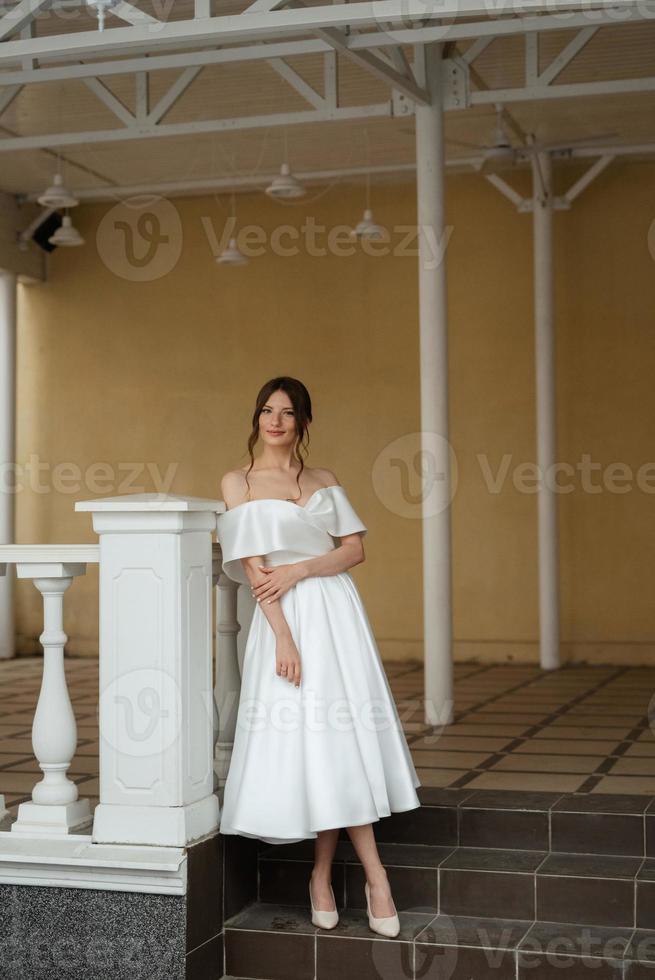 retrato de uma jovem noiva em um vestido branco curto foto