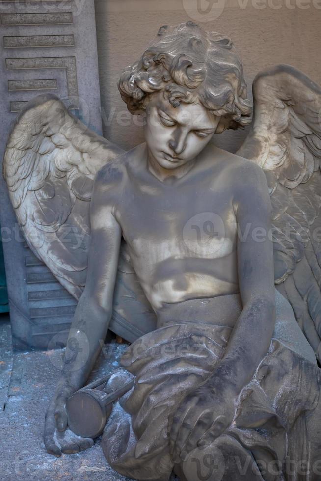 estátua de anjo em um antigo túmulo localizado no cemitério de genoa - itália foto