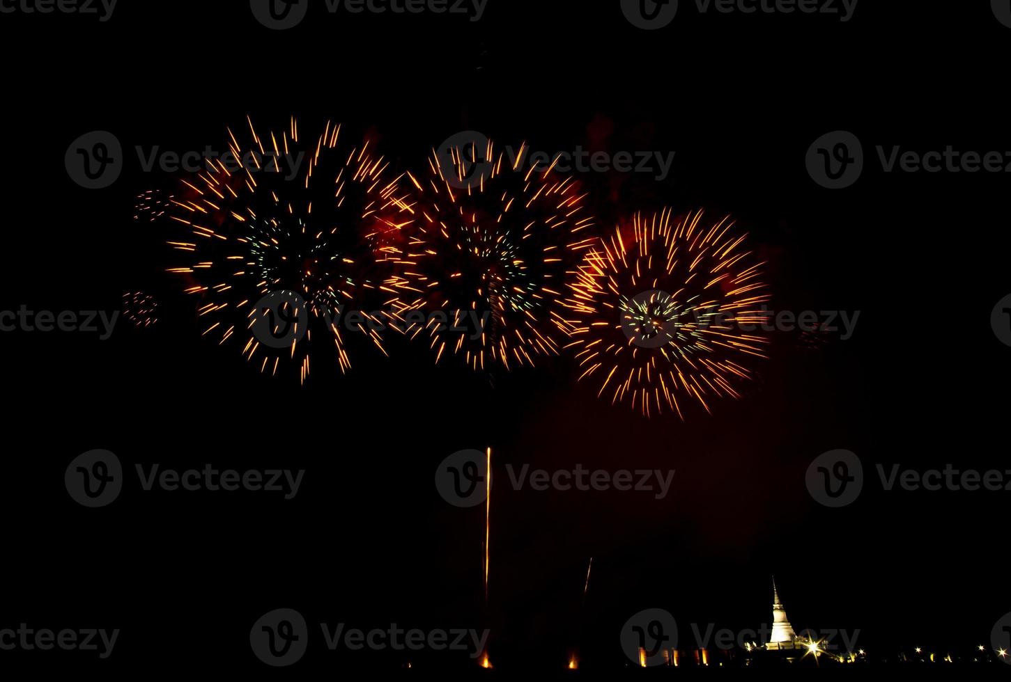 fogos de artifício enormes e coloridos sobre os campos de arroz ao entardecer. foto