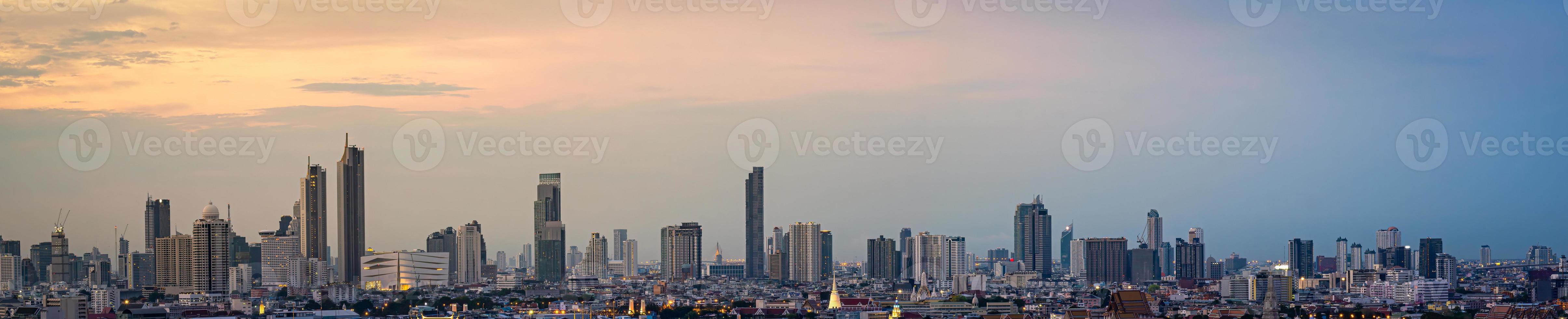 panorama edifício de escritórios alto no centro da cidade de bangkok. ao amanhecer, a luz do céu é laranja. foto