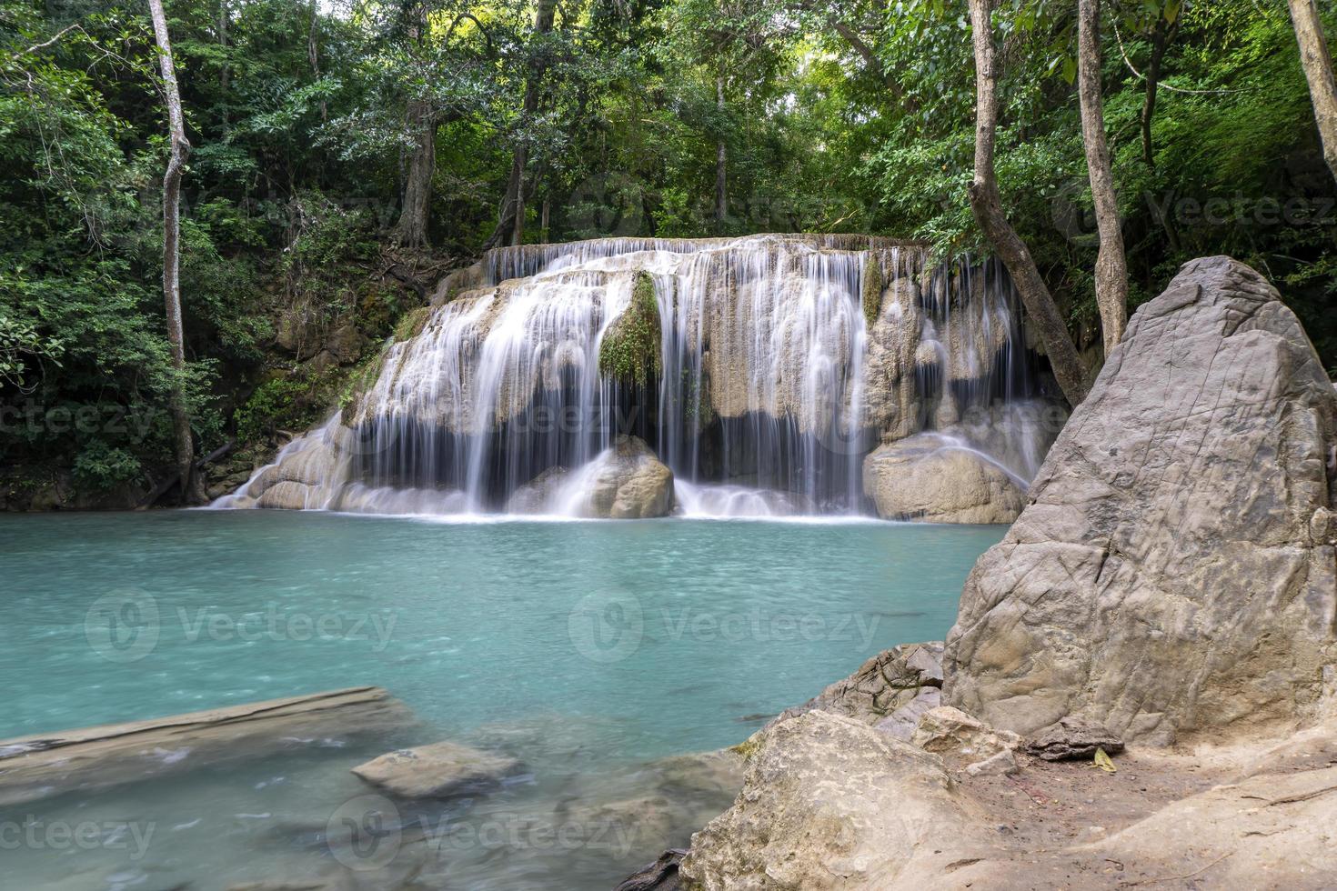 água verde esmeralda limpa da cachoeira cercada por pequenas árvores - árvores grandes, cor verde, cachoeira erawan, província de kanchanaburi, tailândia foto