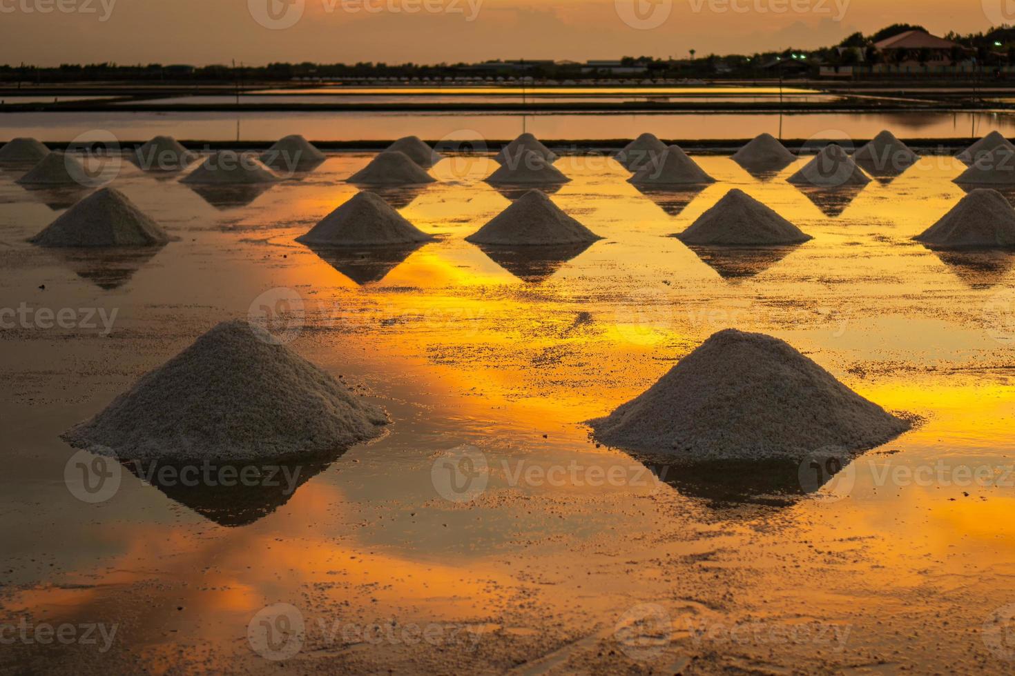 sal nos campos de sal à noite durante a pá de sal na pilha antes de transportar para a loja. foto